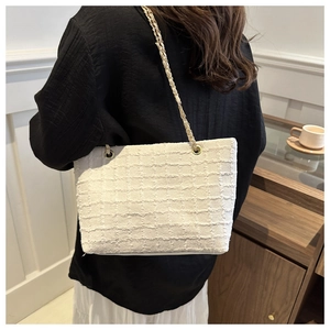 Détail du sac cabas en tweed blanc avec texture tissée et bandoulière chaîne dorée