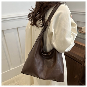 Detail of vintage brown leather tote bag showing soft texture and adjustable strap