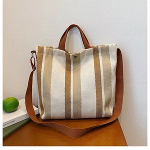 Détail d'un cabas en toile à rayures marron avec fermeture à boucle magnétique