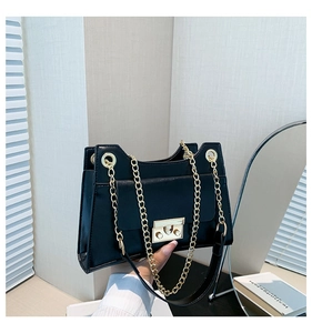 Detail of black faux leather shoulder bag featuring gold chain and metallic buckle lock