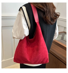 Détail du grand sac cabas en daim rouge foncé avec bandoulière large sur un mannequin