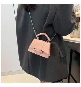 Détail du mini sac bandoulière rose en cuir litchi avec chaîne à perles dorées et boucle