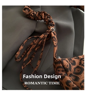 Detail of leopard print tote bag featuring scrunchie shoulder strap and flowing ribbons