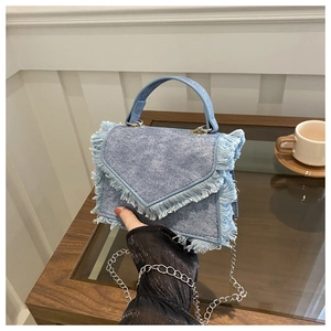 Detail of light blue denim mini handbag with frayed edges and silver chain strap