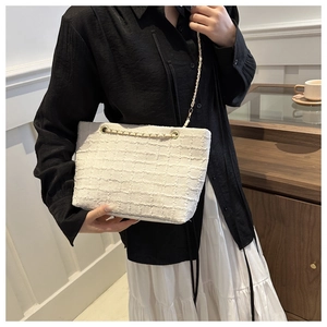 Détail du sac bandoulière en tweed blanc avec texture tissée et chaîne dorée