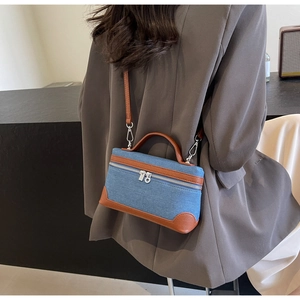 Denim patchwork crossbody bag with brown leather trim shown in a stylish lifestyle setting