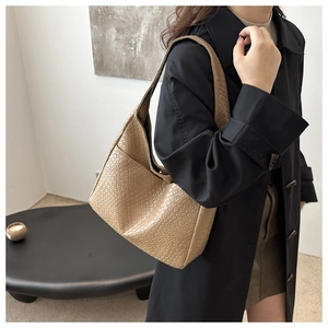 Close-up of khaki woven hobo bag showing detailed checkerboard texture on shoulder