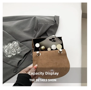 Internal capacity display of a brown suede shoulder bag holding a smartphone and cosmetics