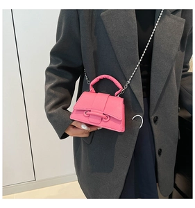 Détail du mini sac rose avec texture litchi, poignée surdimensionnée et chaîne argent