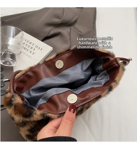 Detail of magnetic metal clasp closure on a leopard print faux fur bucket handbag