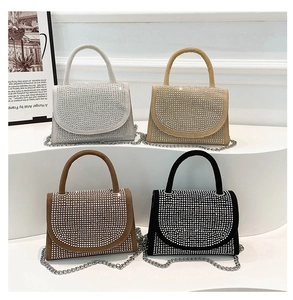 Detail view of rhinestone handbags in four colors displayed on a white tiered stand