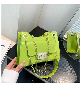 Detail of neon green square shoulder bag with gold chain and metal buckle closure