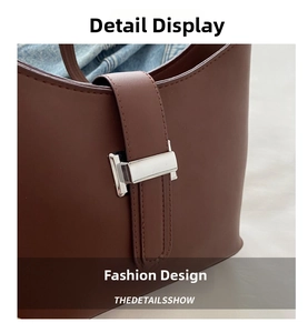 Detailed close-up of dark chocolate leather handbag with silver rectangular clasp