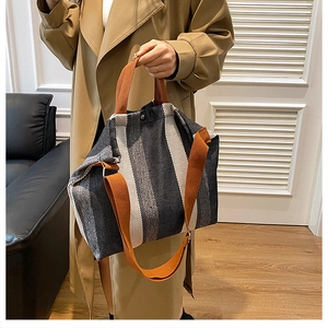 Détail du sac cabas en toile rayée avec poignée orange et bandoulière large réglable