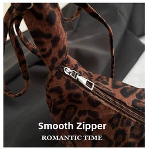 Detail of silver metal zipper and soft leopard print fabric on a stylish tote bag