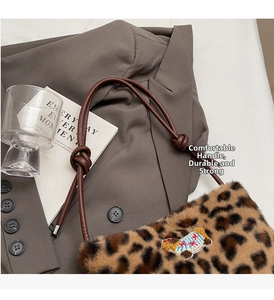 Detail of leopard print plush bag with cartoon dog patch and knotted leather strap