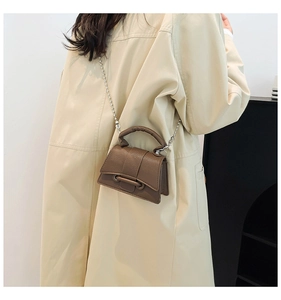 Vue détaillée d'un mini sac carré marron foncé avec une chaîne perlée argentée