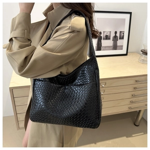 Close-up of black woven leather shoulder bag showing detailed textured weave pattern