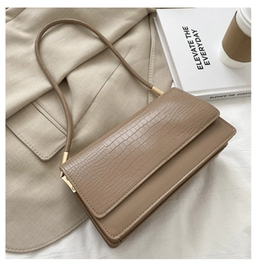 Minimalist beige crossbody bag with croc-embossed flap and gold metal hardware