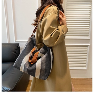 Détail d'un grand sac cabas à rayures noires, blanches et grises avec bandoulière marron