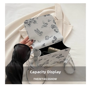 Internal capacity of the white butterfly crossbody bag showing space for a smartphone