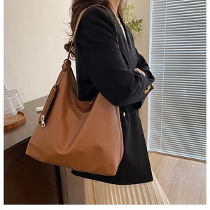 Detail of a brown Hobo shoulder bag showing the soft matte leather and side zipper detail