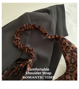 Close-up of pleated cloud-like shoulder strap with leopard print and metal ring detail