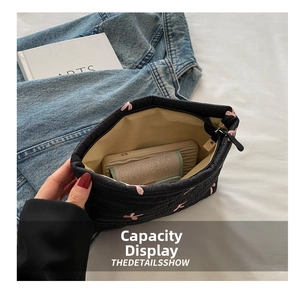 Top view of quilted makeup bag showing spacious interior with phone and wallet inside