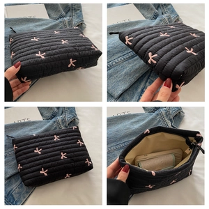 Detailed views of black quilted cosmetic bag with pink bow embroidery and zipper closure