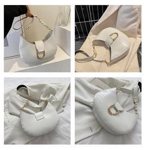 Detail of white crocodile embossed crescent bag with pearl strap and gold buckle