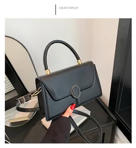 Elegant black faux leather crossbody bag with golden circular ring buckle and top handle