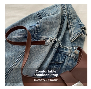 Detail of a brown leather underarm bag featuring a mixed chain and leather shoulder strap