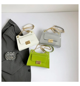 Detailed display of white, silver, and green chain bags with metallic texture and gold locks