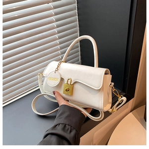 Detail of white leather handbag featuring gold padlock closure and Fashion tag
