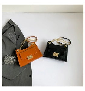 Detail of square crossbody bags featuring gold metal chain straps and flip-lock closures