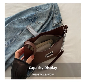 Detail view of brown leather shoulder bag interior capacity with silver metal twist lock