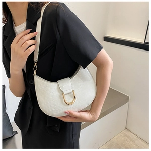 Close-up of white croc-embossed crescent bag with gold D-ring buckle and shoulder strap