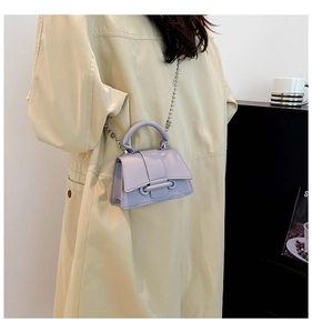 Détail du mini sac lilas en cuir grainé avec fermoir anneau argenté et bandoulière
