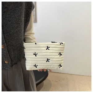 Vue détaillée de la trousse de maquillage en velours côtelé avec broderie papillon noire