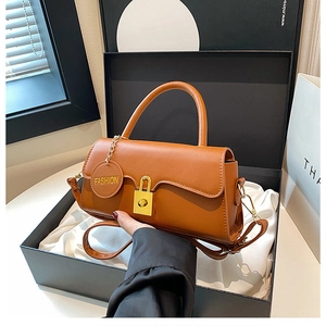 Detailed macro view of caramel PU leather handbag being placed into an elegant gift box