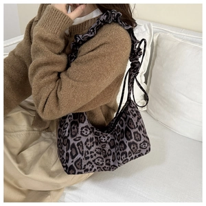 Detail of leopard print crescent bag with pleated shoulder strap for autumn fashion