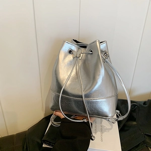 Silver metallic drawstring bucket bag with butterfly metal ornament and leather strap