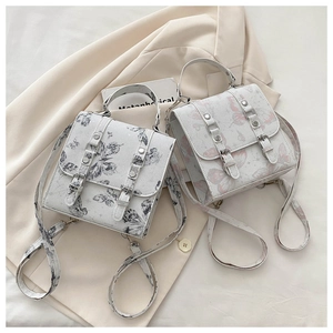 Detail of square butterfly print bags with metallic buckles on a beige blazer