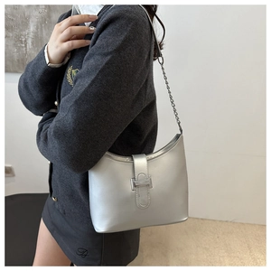 Detail of silver metallic crescent bag featuring sleek chain strap and metal buckle closure