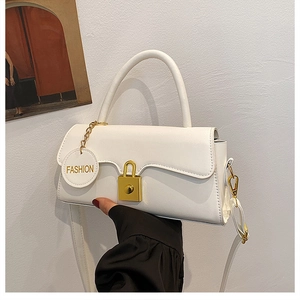 Detail of white vintage crossbody bag featuring gold twist lock and circular logo tag
