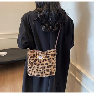 Detail of plush leopard print bucket bag featuring a cute teddy bear embroidery patch