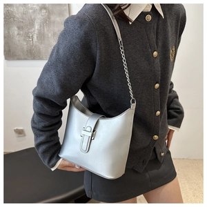 Close-up of metallic silver shoulder bag featuring an elegant chain strap and metal buckle