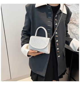 Chic silver rhinestone handbag with chain strap shown on grey suit outfit
