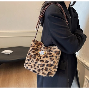 Détail d'un sac à main en peluche léopard avec bandoulière cuir et écusson brodé