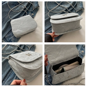 Detail view of grey square bag with silver butterfly lock and crushed texture